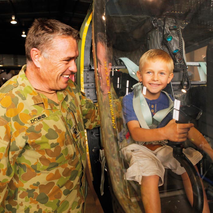 Little boy smiling inside of helicopter at Australian Army Flying Museum in Oakey