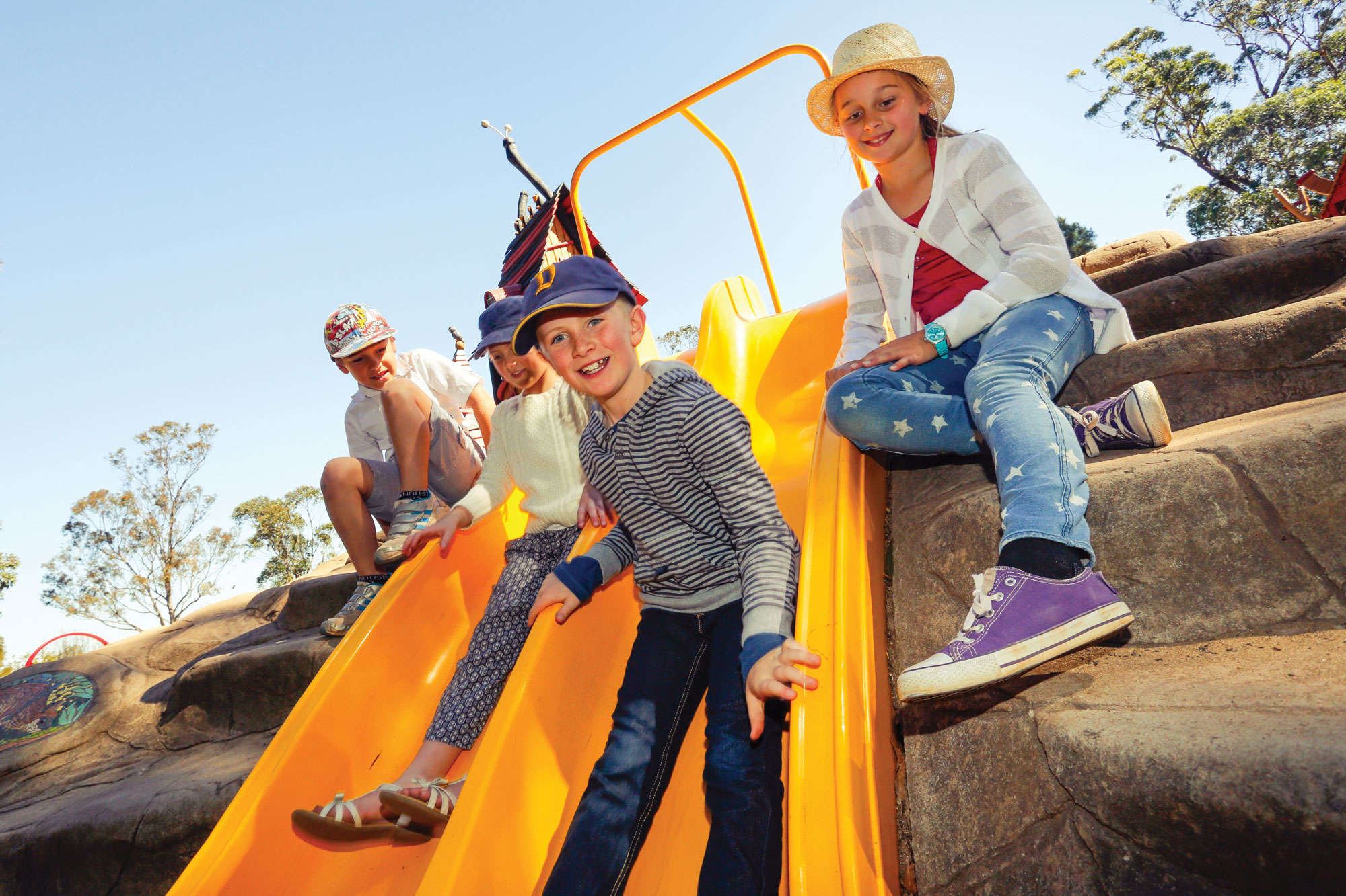 Children on yellow slide in playground